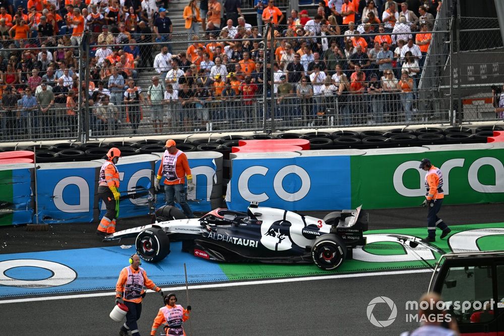 Los oficiales de pista asisten al coche dañado de Daniel Ricciardo, AlphaTauri AT04