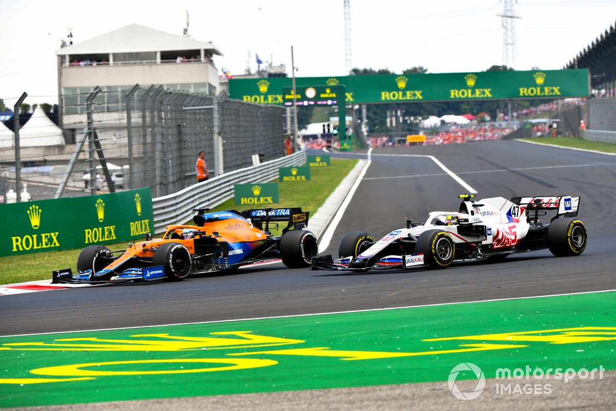 Daniel Ricciardo, McLaren MCL35M, melewati Mick Schumacher, Haas VF-21