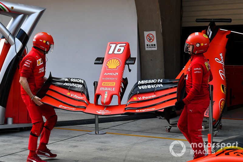 Mecccanici Ferrari con l'ala anteriore della Ferrari SF90
