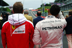 (Da sx a dx): Kimi Raikkonen, Ferrari e Lewis Hamilton, Mercedes AMG F1 mentre la griglia osserva l'