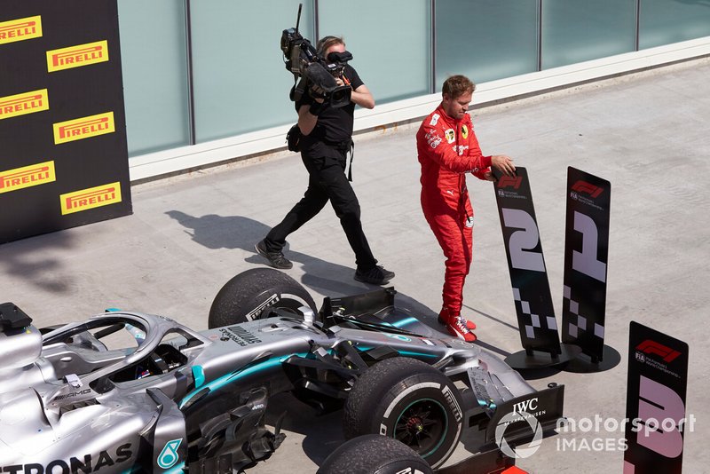 Le deuxième, Sebastian Vettel, Ferrari, change les panneaux dans le Parc Fermé