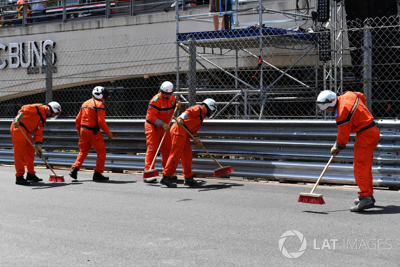 Les commissaires nettoient la piste après le crash de Max Verstappen, Red Bull Racing RB14