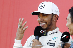 Lewis Hamilton, Mercedes AMG F1, tries on Takuma Sato's Indy 500 Winner's ring on the podium