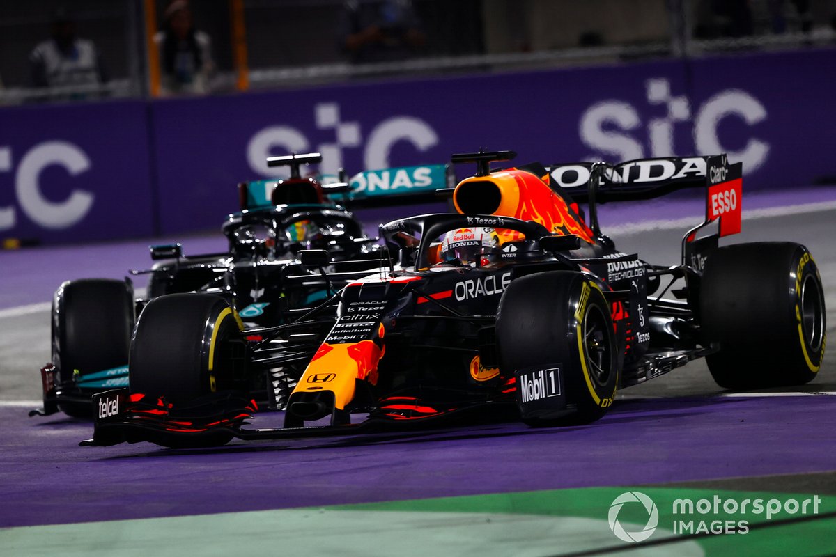 Max Verstappen, Red Bull Racing RB16B, y Lewis Hamilton, Mercedes W12, hacen un contacto en su batalla.