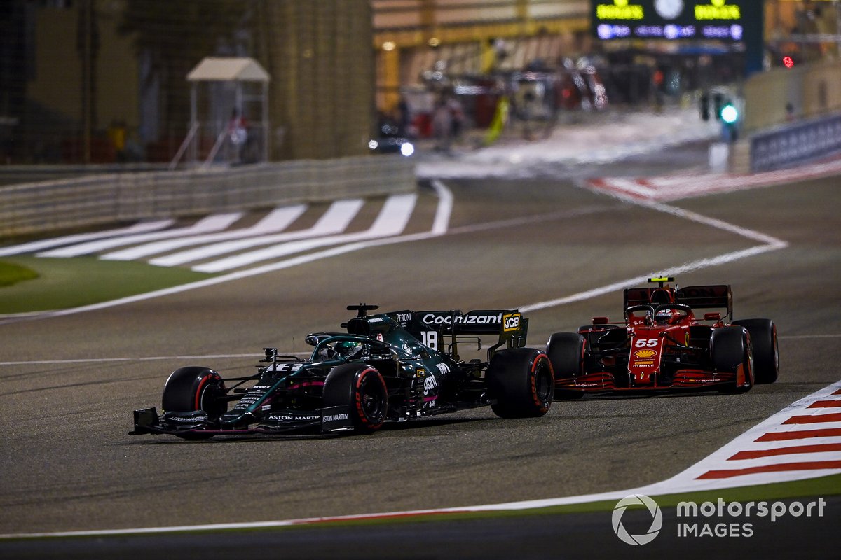 Pembalap Scuderia Ferrari yang turun dengan Ferrari SF21, Carlos Sainz Jr (kanan), menempel Lance Stroll, pembalap Aston Martin, pada lomba GP Bahran, Minggu (28/3/2021) malam lalu.