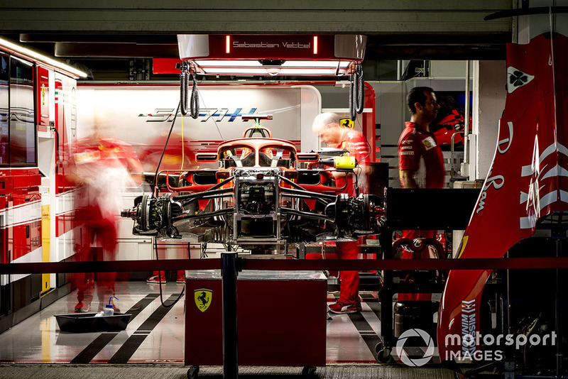 Engineers work on the car of Sebastian Vettel, Ferrari SF71H, in the garage