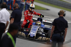 Sebastian Vettel, Ferrari, rides back to the pits on the sidepod of the Pascal Wehrlein Sauber C36