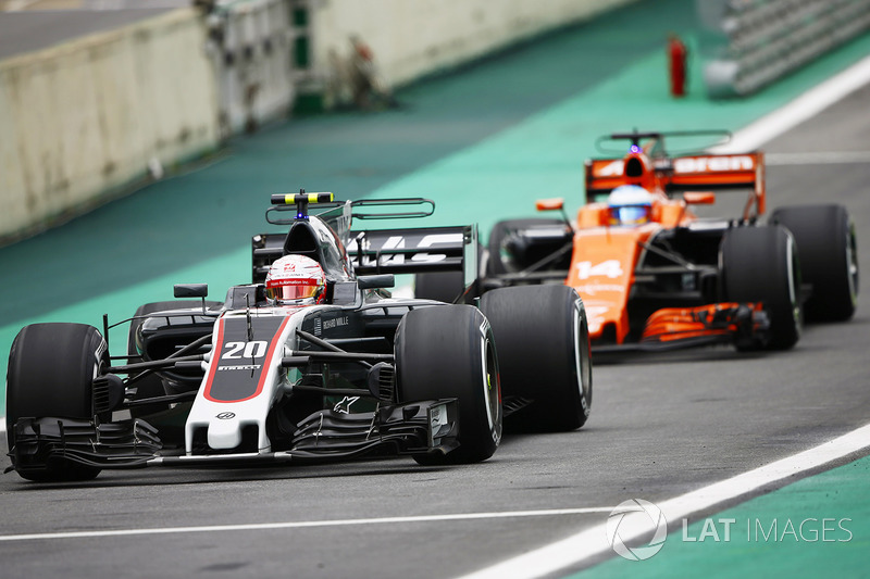 Kevin Magnussen, Haas F1 Team VF-17, Fernando Alonso, McLaren MCL32, en pit lane