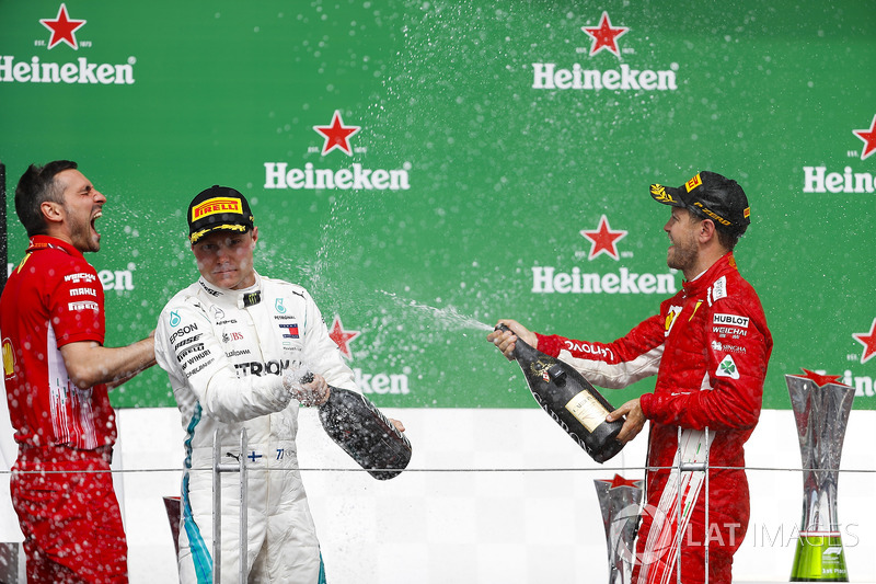 Valtteri Bottas, Mercedes AMG F1, y Sebastian Vettel, Ferrari, celebran en el podio
