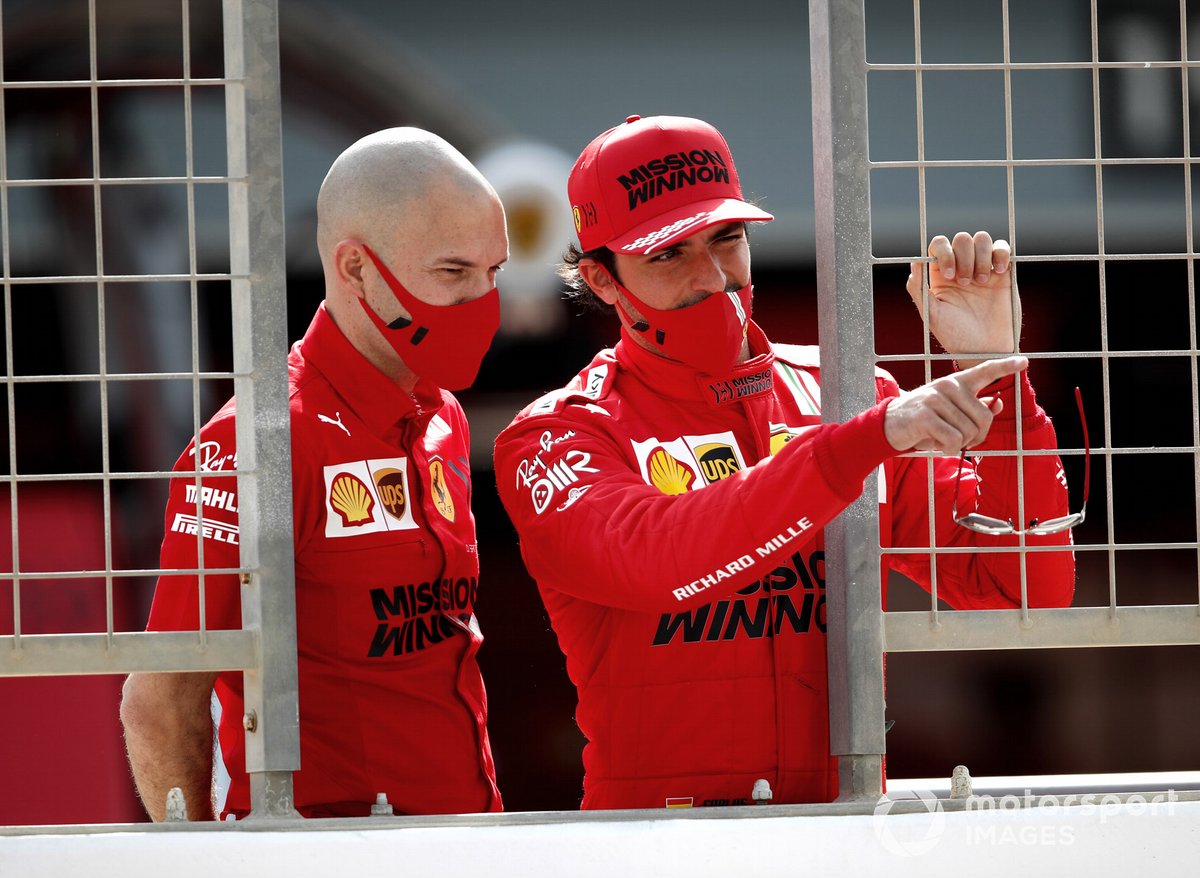 Pembalap Tim Scuderia Ferrari, Carlos Sainz Jr (kanan), terlihat tengah mengamati sebuah mobil F1 lawan dalam latihan pramusim di Bahrain lalu bersama seorang teknisi Ferrari.