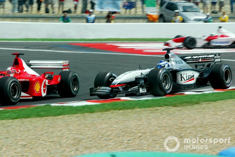 Kimi Raikkonen, McLaren Mercedes MP4/17 gaat wijd en Michael Schumacher, Ferrari F2002 passeert hem.