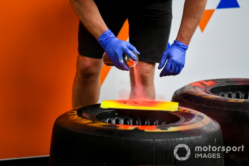 McLaren mechanic spray painting Pirelli tyre