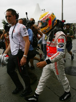 Lewis Hamilton, McLaren Mercedes, returns to the paddock after retiring from the race