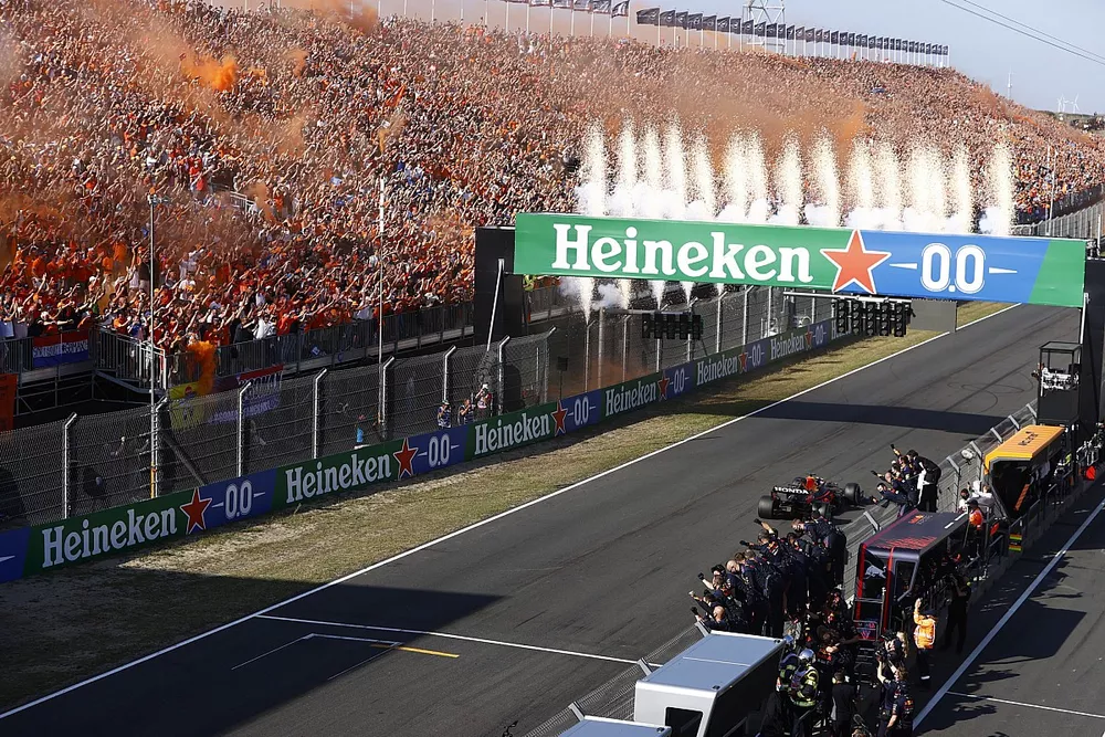 Vuurwerk barst los als Max Verstappen, Red Bull Racing RB16B, 1e positie, de overwinning pakt tot grote vreugde van zijn team aan de pitmuur en de fans op de tribunes