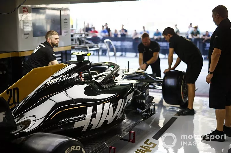 Les m&eacute;caniciens travaillent sur la voiture de Kevin Magnussen, Haas F1 Team VF-19 dans le garage