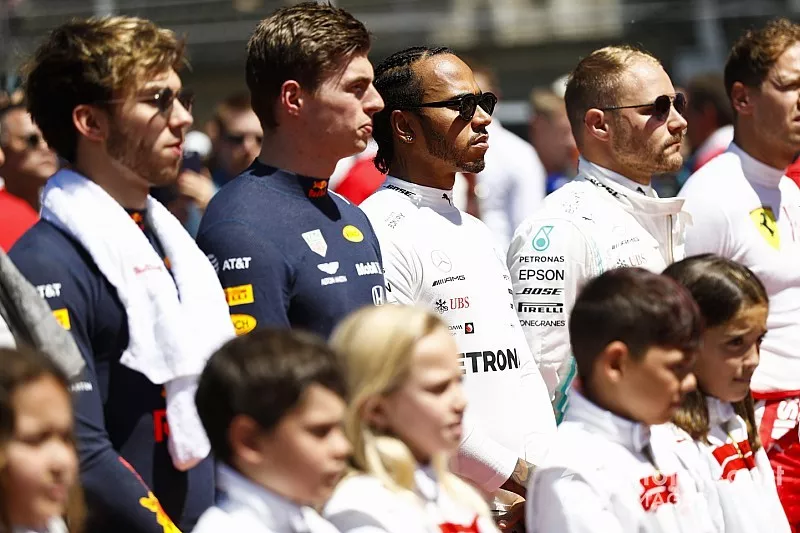 Pierre Gasly, Red Bull Racing, Max Verstappen, Red Bull Racing, Lewis Hamilton, Mercedes AMG F1, and Valtteri Bottas, Mercedes AMG F1, line up with the grid kids for the national anthem prior to the start