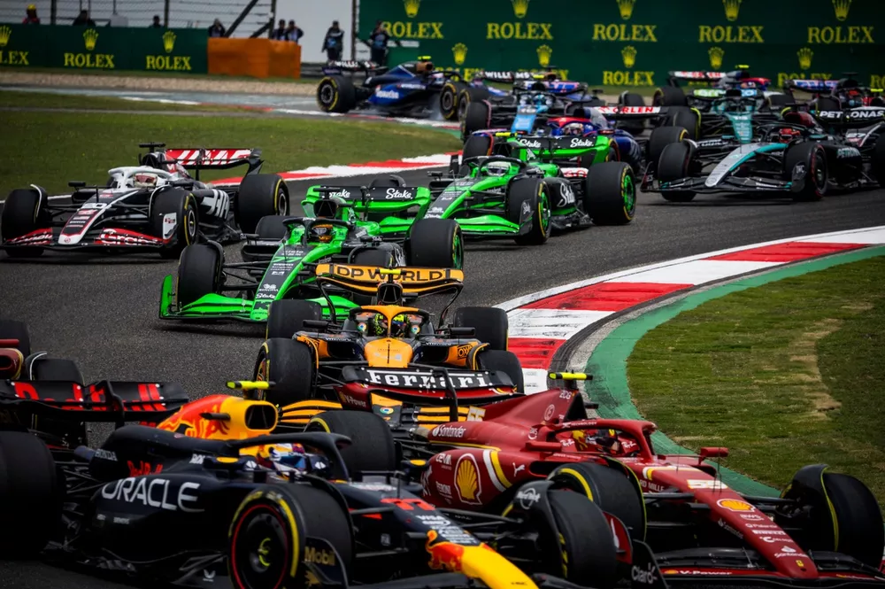 Sergio Perez, Red Bull Racing RB20, leads Carlos Sainz, Ferrari SF-24, Lando Norris, McLaren MCL38, Valtteri Bottas, Kick Sauber F1 Team C44, Kevin Magnussen, Haas VF-24, and the remainder of the field on the opening lap of the Sprint