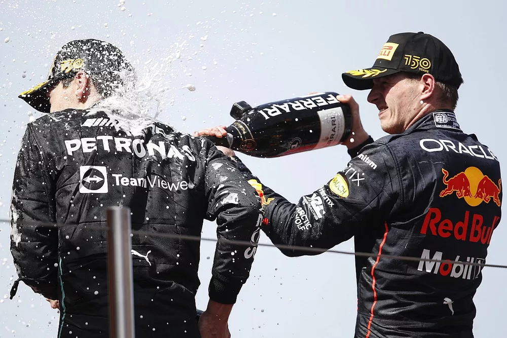 Sergio Perez, Red Bull Racing, 2nd position, Max Verstappen, Red Bull Racing, 1st position, soak George Russell, Mercedes-AMG, 3rd position, in Champagne on the podium
