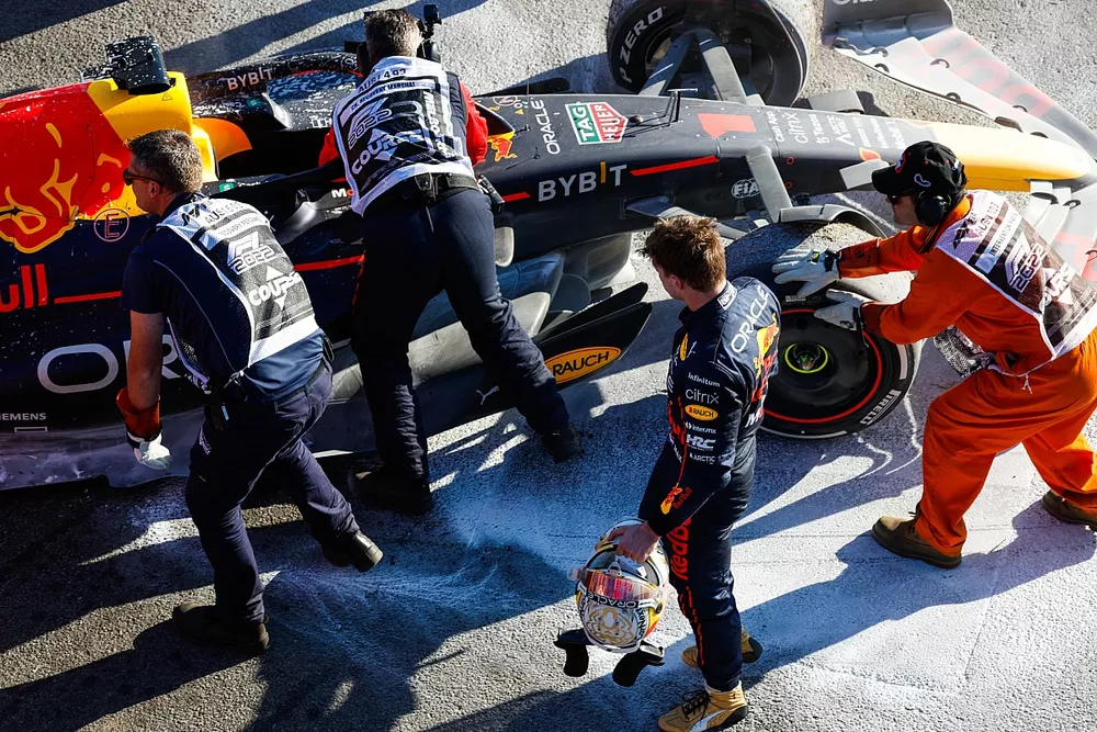 Marshals assisteren Max Verstappen, Red Bull Racing, na opgave voor de race