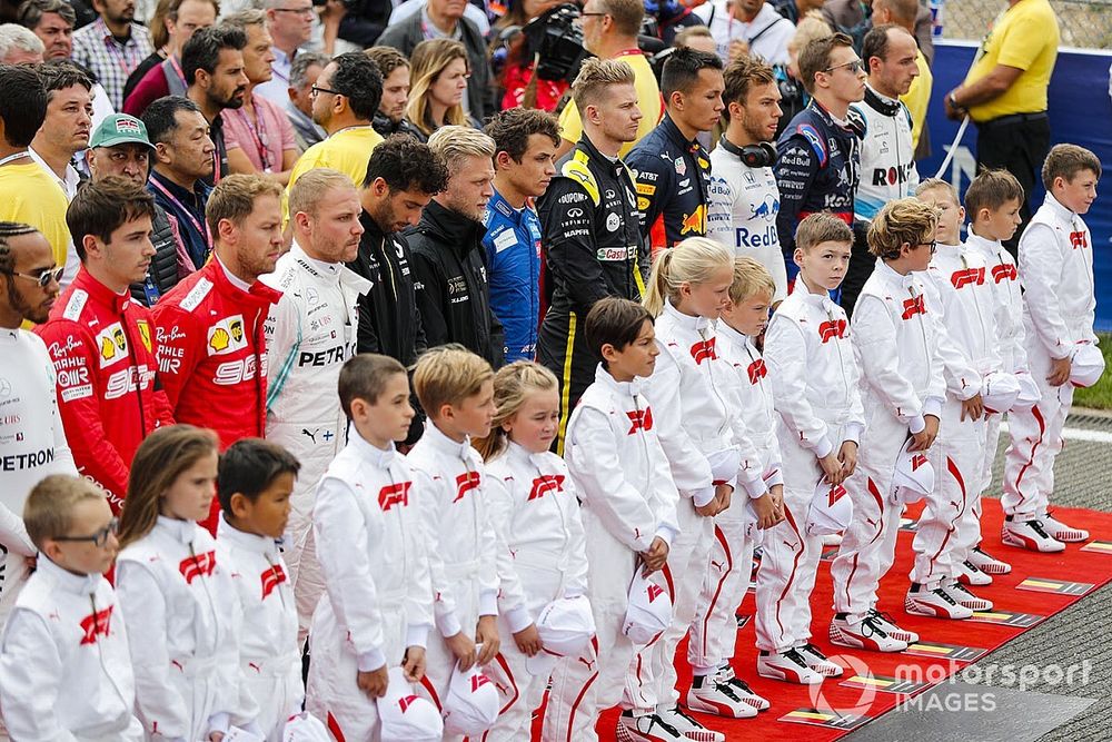 Los pilotos se unen a las mascotas de Grid Kid para el himno nacional antes de la salida