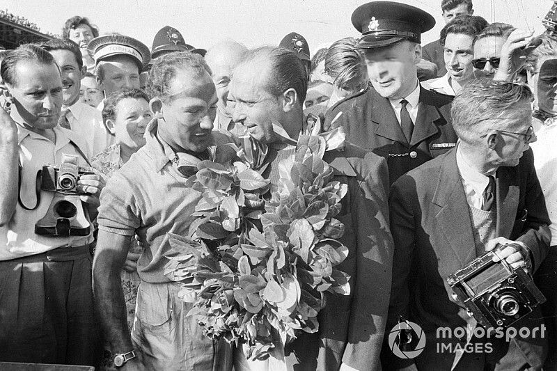 Stirling Moss gives his winner's garland to Juan Manuel Fangio