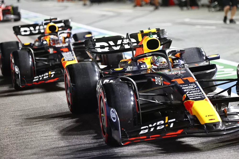 Sergio Perez, Red Bull Racing RB19, precede Max Verstappen, Red Bull Racing RB19, ai box.