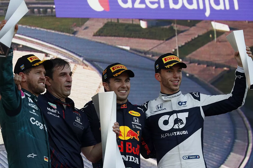Sebastian Vettel, Aston Martin, 2nd position, the Red Bull trophy delegate, Sergio Perez, Red Bull Racing, 1st position, and Pierre Gasly, AlphaTauri, 3rd position, on the podium