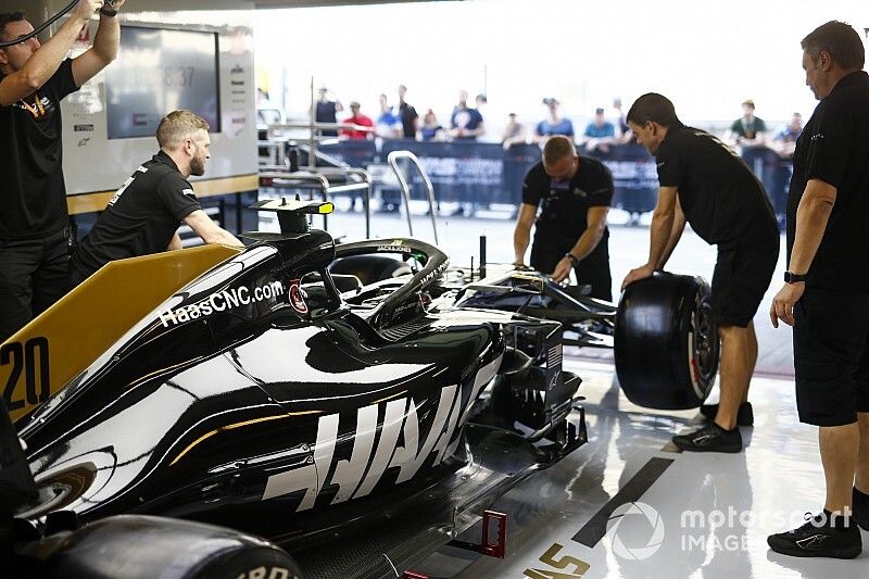 Mechanics work on the Kevin Magnussen Haas F1 Team VF-19 in the team's pit garage