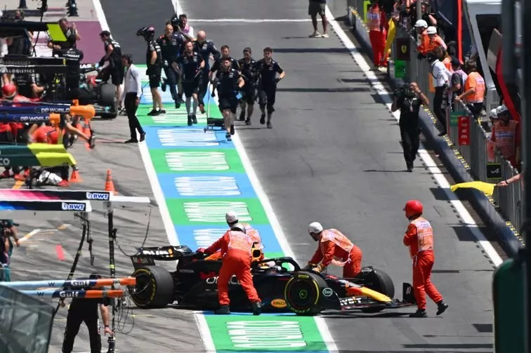 Marshals push the stopped car of Max Verstappen, Red Bull Racing RB20, in the pit lane