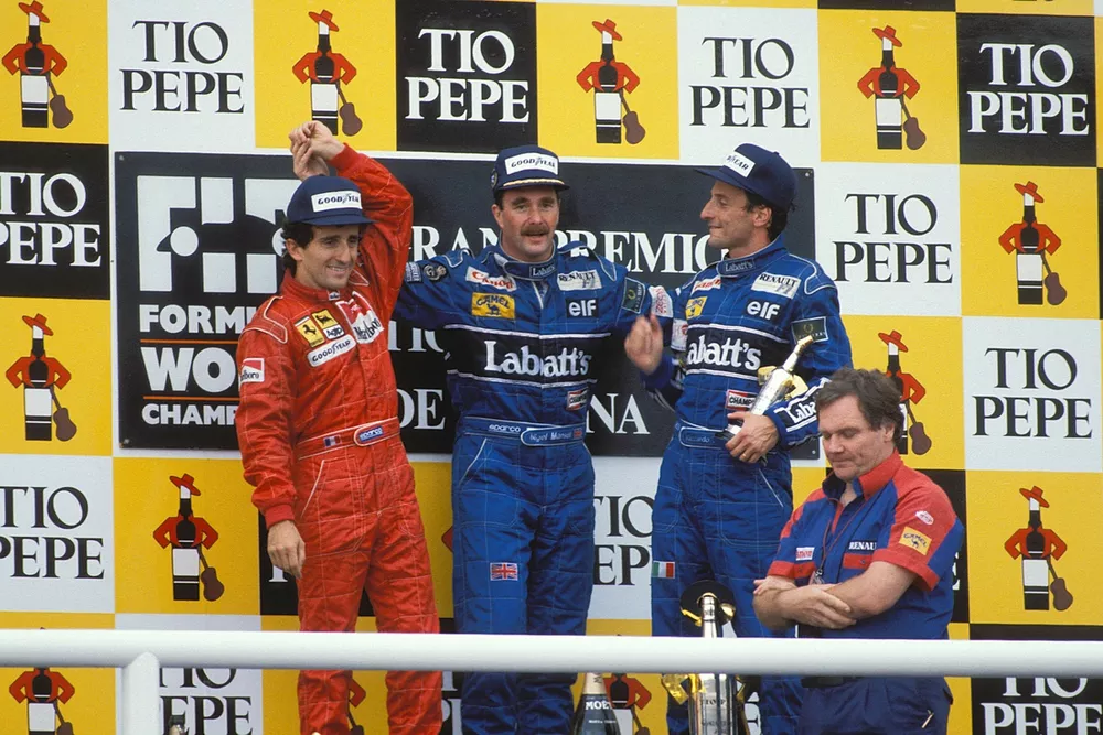 Nigel Mansell, 1ª posición, celebra en el podio con Alain Prost, 2ª posición, Riccardo Patrese, 3ª posición, y Patrick Head de Williams.