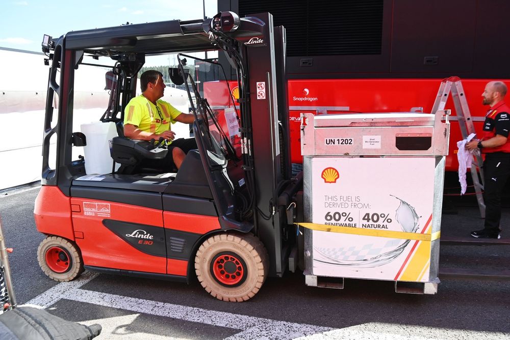 Um motorista de empilhadeira move um palete de combustível
