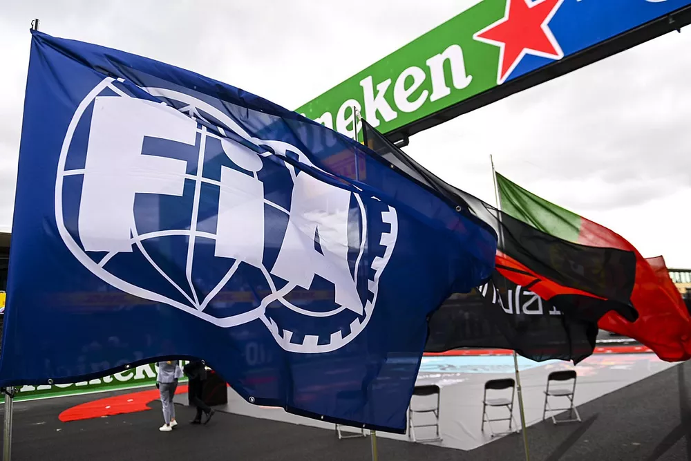 A huge FIA flag flies on the grid