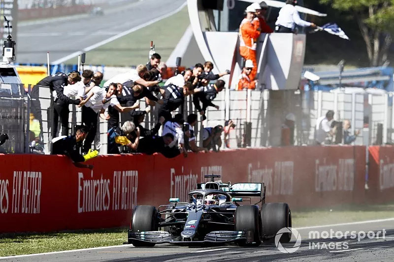 El ganador de la carrera pasa por encima de la línea de meta con la bandera a cuadros ondeando con el Mercedes AMG F1 celebrando 