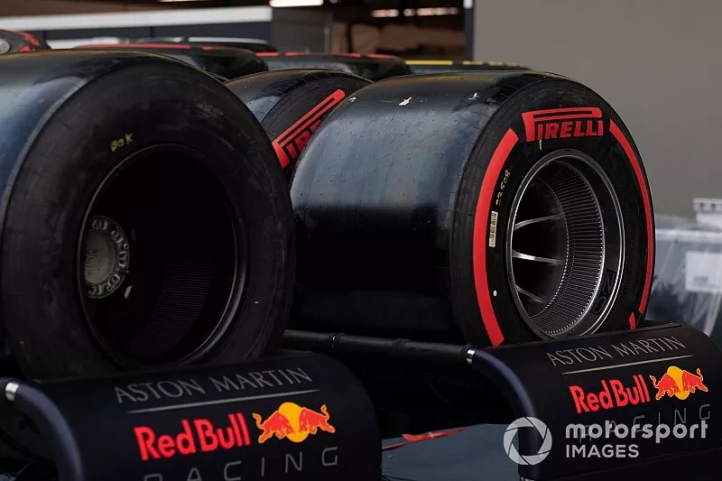 Pirelli tyres allocated to Red Bull are pushed on a trolley through the pit lane