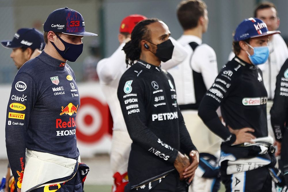 Max Verstappen, de Red Bull Racing, Lewis Hamilton, de Mercedes, Fernando Alonso, de Alpine F1, y el resto de pilotos se colocan en la parrilla para escuchar el himno nacional antes de la salida