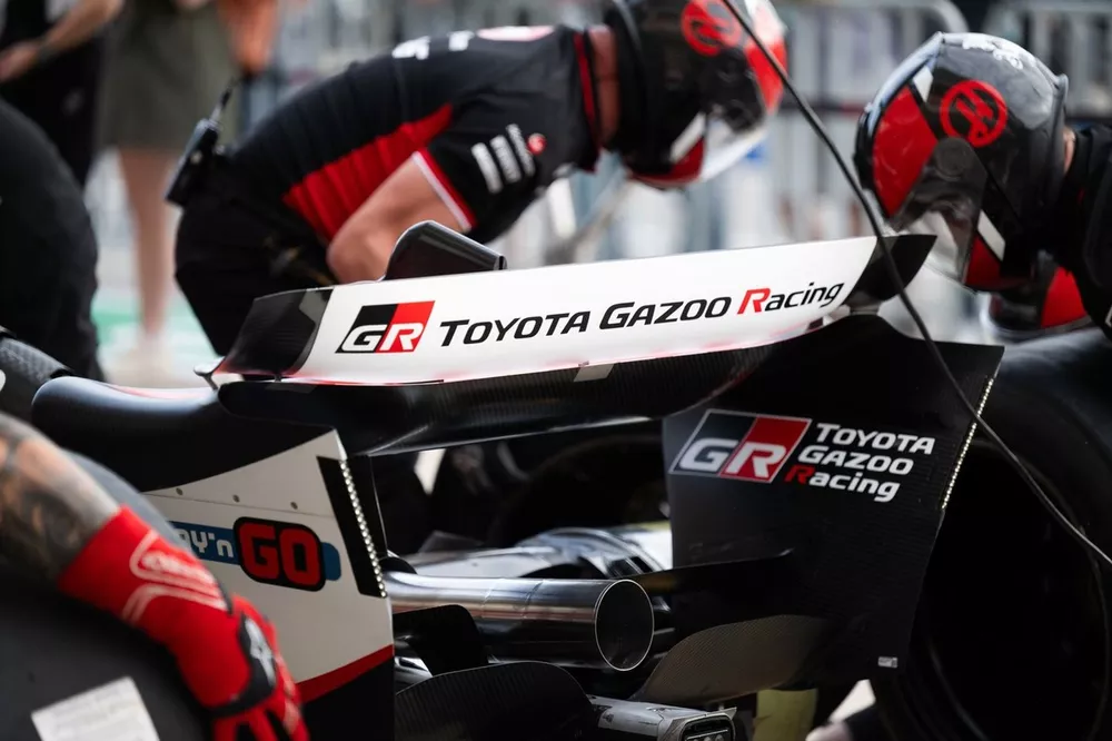 Haas team members practice a pit stop. Toyota branding is visible on the rear wing