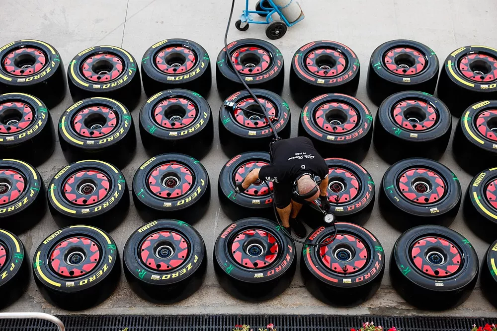 An Sauber team member works on Pirelli tyres