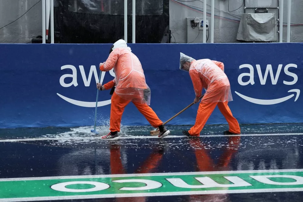 Os fiscais varrem a &aacute;gua no pit lane