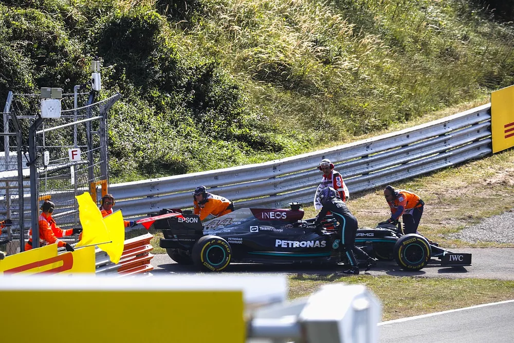 Los oficiales de pista asisten a Lewis Hamilton, de Mercedes, tras una aver&iacute;a en la FP2