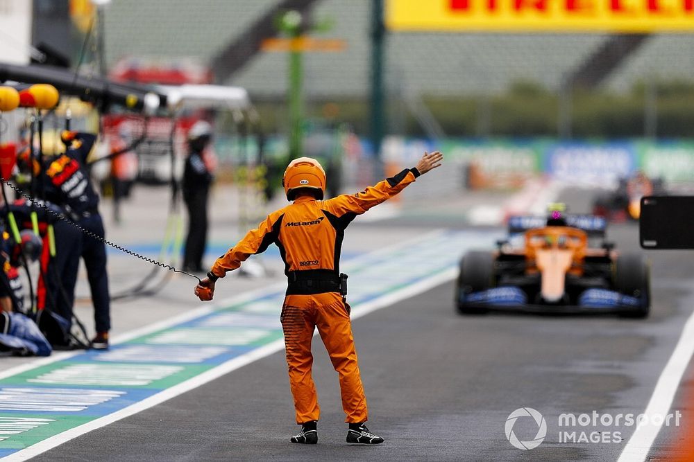 A McLaren mechanic directs Lando Norris, McLaren MCL35