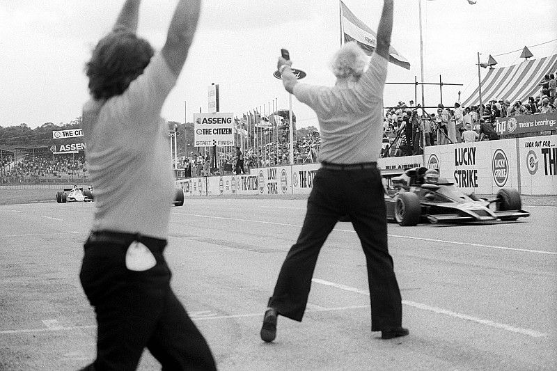 Colin Chapman, propietario del equipo Lotus, celebra mientras Ronnie Peterson, Lotus 78 cruza la línea de meta para ganar el GP 