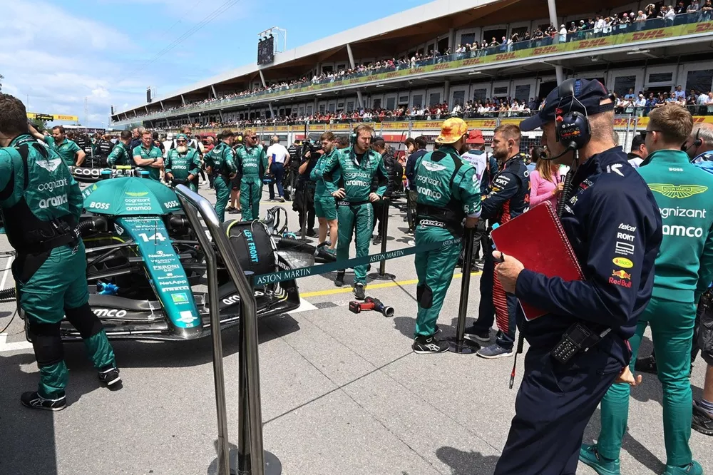 Adrian Newey, director técnico de Red Bull Racing, revisa el coche de Fernando Alonso, Aston Martin AMR23, en la parrilla