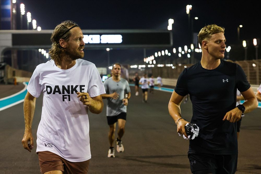 Sebastian Vettel, Aston Martin, es acompañado en una carrera alrededor del circuito por Mick Schumacher, Haas F1 Team, con los buenos deseos como parte de su despedida en su último Gran Premio