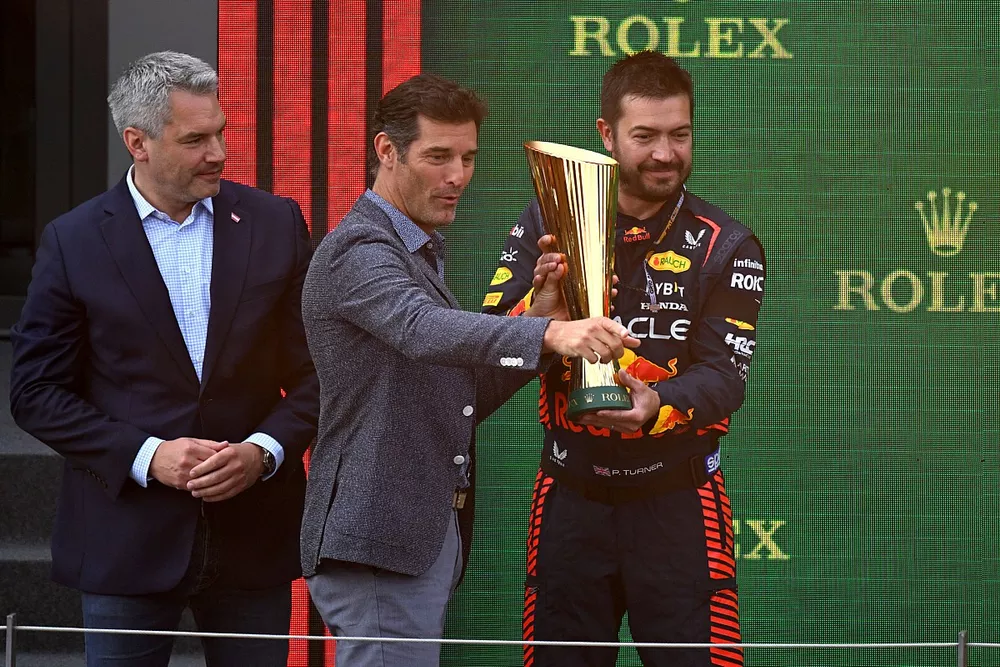 The Red Bull trophy delegate collects the Constructors trophy from Mark Webber