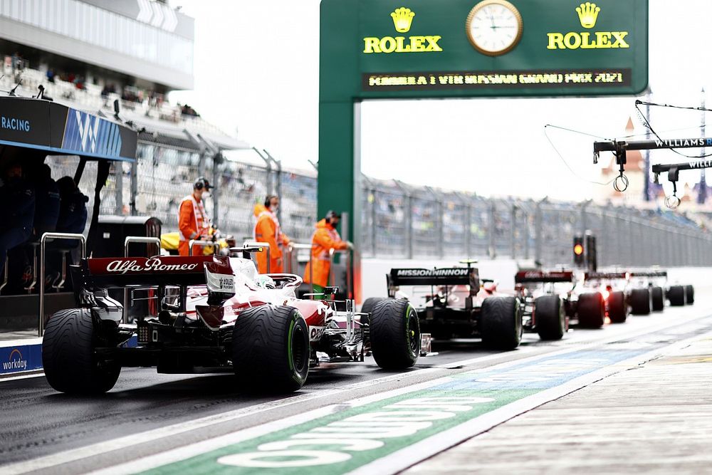 Carlos Sainz Jr., Ferrari SF21, Antonio Giovinazzi, Alfa Romeo Racing C41, en el pit lane