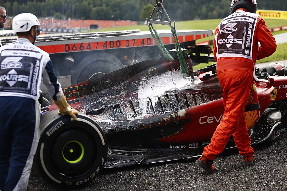 Marshals remove the fire damaged car of Carlos Sainz, Ferrari F1-75, from the circuit
