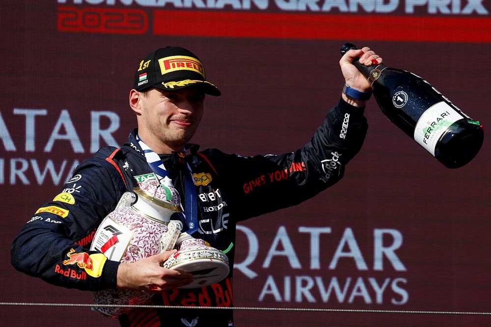 Podio: ganador Max Verstappen, Red Bull Racing con su trofeo roto