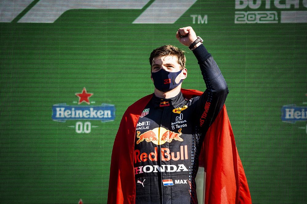 Max Verstappen, Red Bull Racing, 1st position, wears a Dutch flag as a cape on the podium