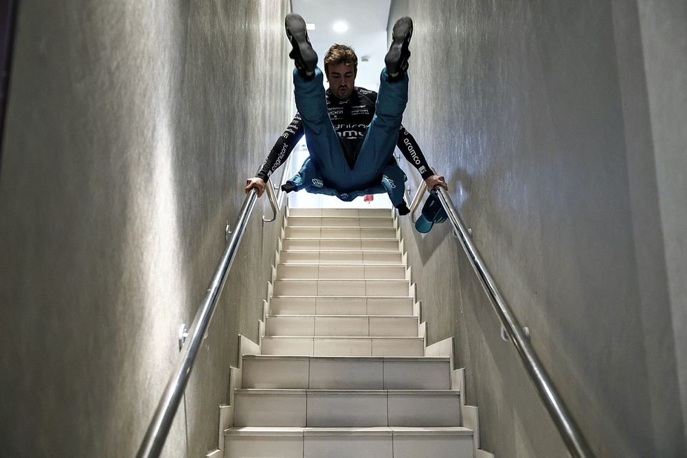 Fernando Alonso, Aston Martin F1 Team, swings on the bannisters