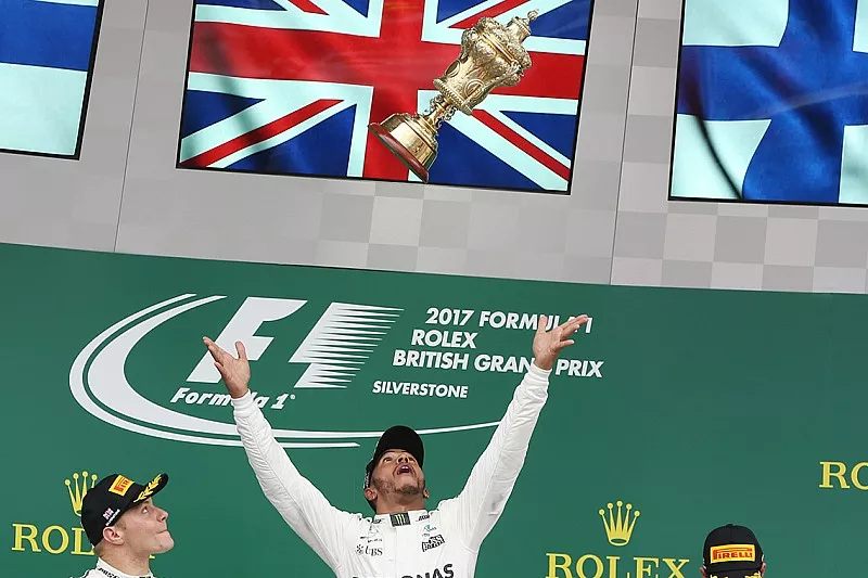 Racewinnaar Lewis Hamilton, Mercedes AMG F1 gooit zijn trofee in de lucht